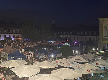 Luftbild einer großen Anzahl von Zeltdächern und Menschen im Dunkeln.